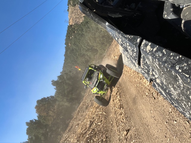Green UTV ripping down a dirt trail
